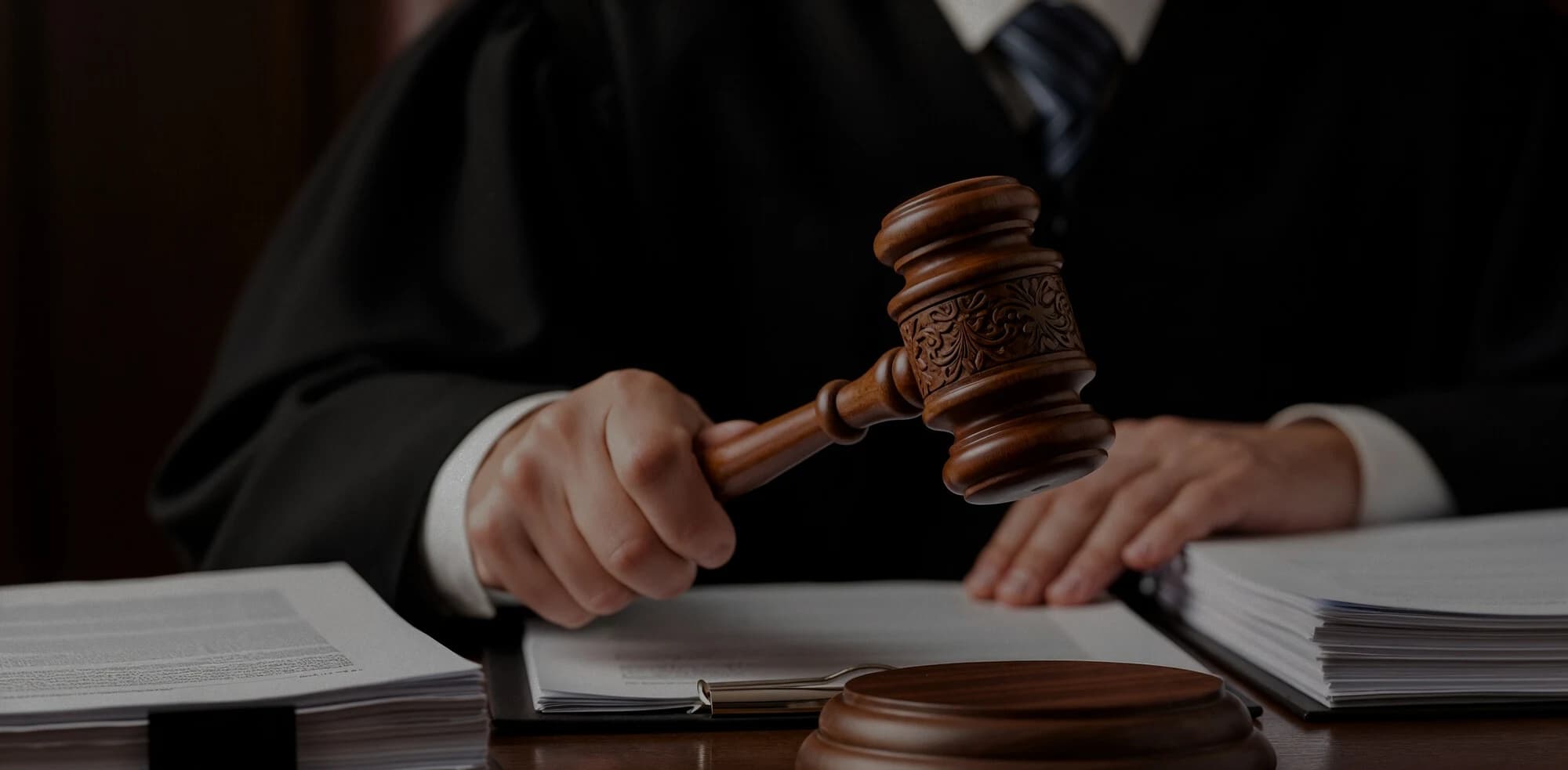 Judge holding a gavel over case documents in a courtroom